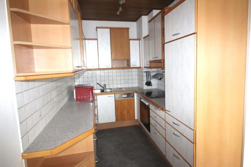 a small kitchen with wooden cabinets and white appliances at Geräumige Ferienwohnung im Zentrum in Sankt Pölten