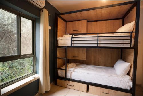 a bunk bed in a room with a window at Mantur Parod by Selina in Parod