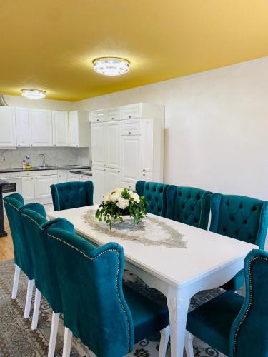 a dining room with a white table and blue chairs at Apartman Kula in Gradačac