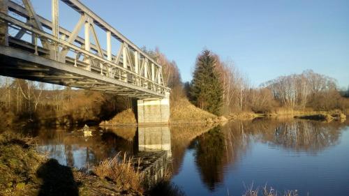 a bridge over a river with its reflection in the water at Apartmán PECKA - Nová Pec in Nová Pec