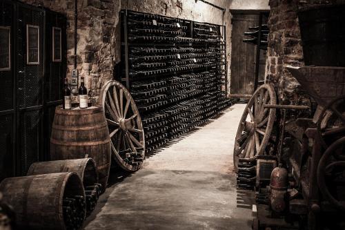a wine cellar with wine bottles and wooden wheels at Cà del Re in Verduno
