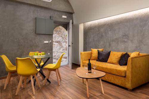 a living room with a yellow couch and a table at Zoe Suites in Rhodes Town