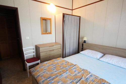 une chambre avec un lit, une commode et un miroir dans l'établissement Belle villa de Vacances en angle climatisée, domaine TAMARIS, 4 chambres 7-9 couchages, Wifi, accès aux piscines payant, 900m de la mer LRTAMQ10, à Portiragnes