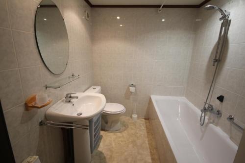 une salle de bain avec un lavabo, des toilettes et une baignoire dans l'établissement Belle villa de Vacances en angle climatisée, domaine TAMARIS, 4 chambres 7-9 couchages, Wifi, accès aux piscines payant, 900m de la mer LRTAMQ10, à Portiragnes