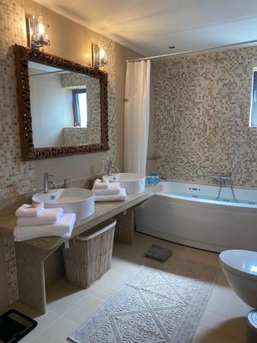 a bathroom with two sinks and a tub and a mirror at Villa Muse in Agios Nikolaos