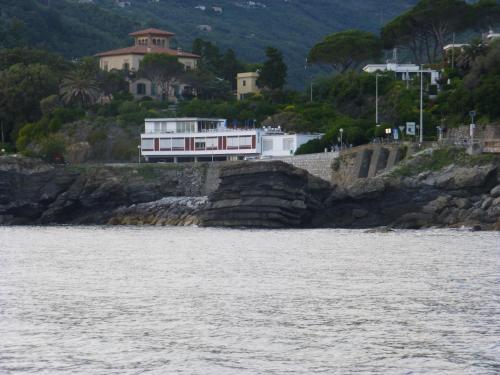 a house on a cliff next to a body of water at Hotel La Scogliera in Cavi di Lavagna