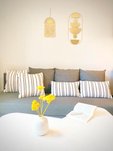 un salon avec un canapé et une table avec des fleurs dans l'établissement HOSSEGOR Plage & Golf, à Hossegor