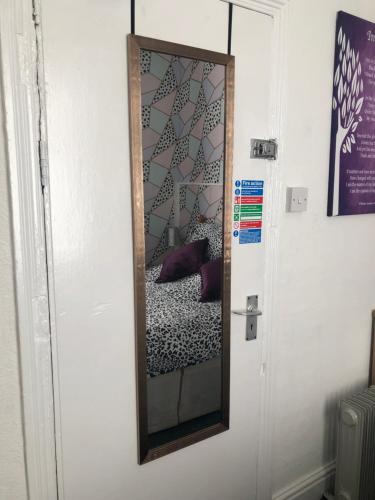 a mirror hanging on a wall next to a door at The Franklyn Hotel B&B in Blackpool