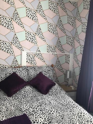 a bedroom with a bed with a geometric wall at The Franklyn Hotel B&B in Blackpool
