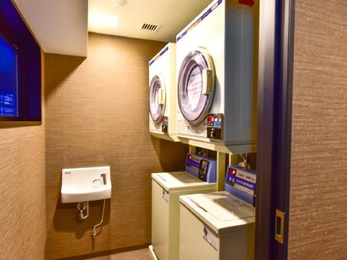 a bathroom with a washing machine and a sink at HOTEL LiVEMAX Fukuoka Tenjin West in Fukuoka