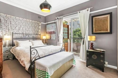 een slaapkamer met een bed en een raam bij Beach to home in 3 minutes: Bondi N in Sydney