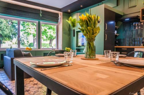 a large wooden table with a vase of flowers on it at Le T.Green in La Gorgue
