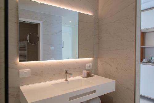 a bathroom with a white sink and a mirror at THE ONE CAORLE - Hotel & Apartments in Caorle