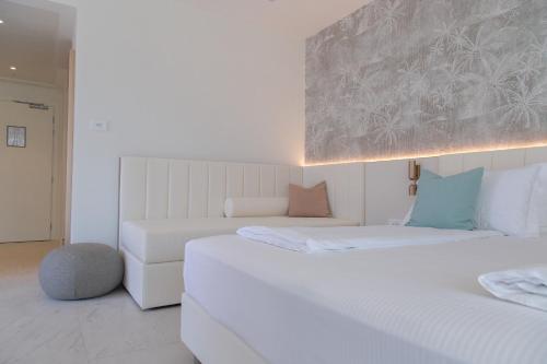 two beds in a room with white walls and blue pillows at THE ONE CAORLE - Hotel & Apartments in Caorle