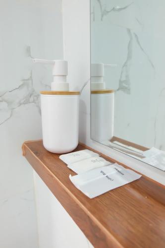 a bottle of moisturizing cream sitting on a wooden shelf at Order Residence in Ban Pa Muat