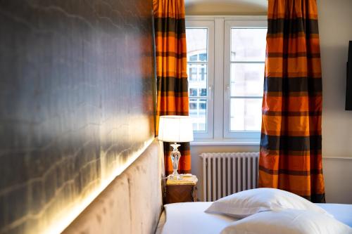 a bedroom with a bed and a window at Hotel Suisse in Strasbourg
