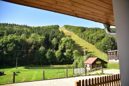 a view of a hill with a house and a field at Pension U Krbu in Mikulov v Krušných Horách