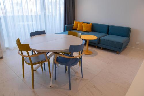 a living room with a table and chairs and a couch at THE ONE CAORLE - Hotel & Apartments in Caorle