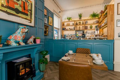 a blue dining room with a table and a fireplace at Rowntree Lodge in Scarborough