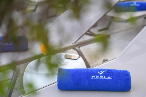 a blue object is sitting next to a flower at Hotel Perla in Herceg-Novi