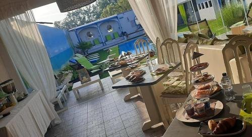 ein Zimmer mit Tischen und Stühlen mit Essen drauf in der Unterkunft Lady Hamilton B&B in Feletto