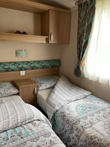 two beds in a small room with a window at Swift bordeaux 24 in Dunoon