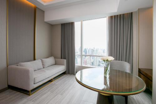 a living room with a couch and a glass table at Centara Grand At CentralWorld in Bangkok