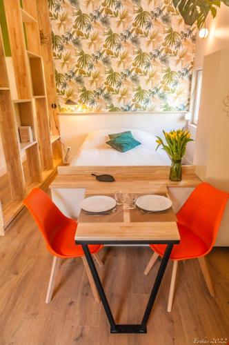 Zimmer mit einem Bett, einem Tisch und Stühlen in der Unterkunft Le T.Wood in La Gorgue
