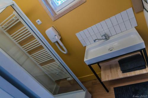 ein Bad mit einem Waschbecken und einem Spiegel in der Unterkunft Le T.Wood in La Gorgue