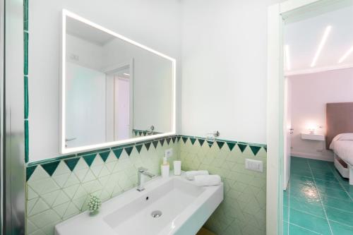 een badkamer met een witte wastafel en een spiegel bij Incanto apartament stunning sea view in Nerano
