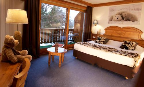 a bedroom with a bed and a teddy bear in a room at Hôtel Serre Palas in Les Deux Alpes
