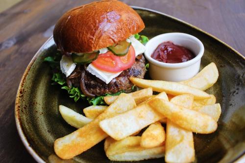 a plate with a hamburger and french fries andetchup at Meriton Old Town Garden Hotel in Tallinn