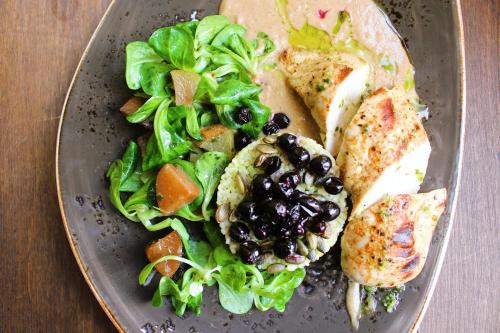 a plate of food with chicken and a salad at Meriton Old Town Garden Hotel in Tallinn