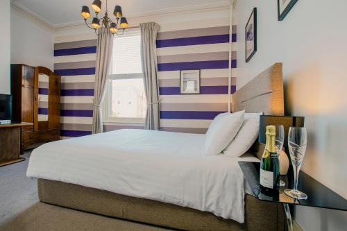 a bedroom with a bed with blue and white stripes at Rowntree Lodge in Scarborough
