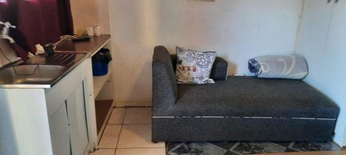 a couch in the corner of a kitchen with a sink at Open View Guest Inn in Kempton Park