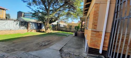 a house with a tree next to a driveway at Open View Guest Inn in Kempton Park