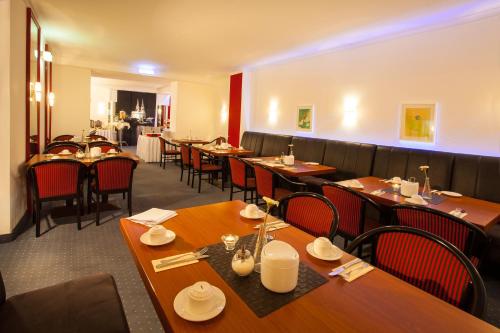 a dining room with wooden tables and chairs at Centro Hotel Royal in Cologne