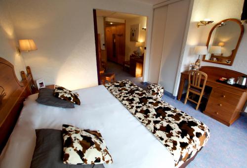 a hotel room with a bed with cows on it at Hôtel Serre Palas in Les Deux Alpes