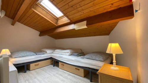 2 Betten in einem Zimmer mit einer Decke und einem Fenster in der Unterkunft RETOUR AUX SOURCES in Royan