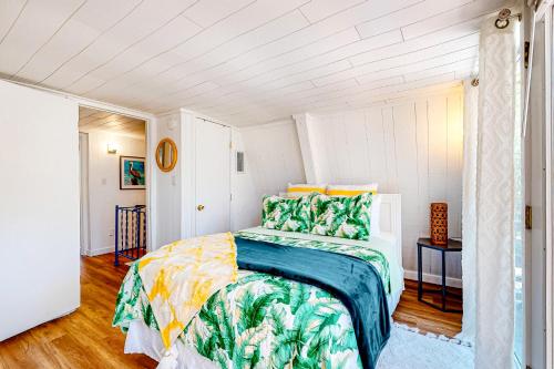 a bedroom with a bed with green and yellow sheets at High Tide Hideaway in Dauphin Island