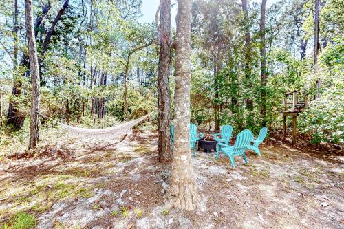 a hammock and a table and chairs in the woods at High Tide Hideaway in Dauphin Island