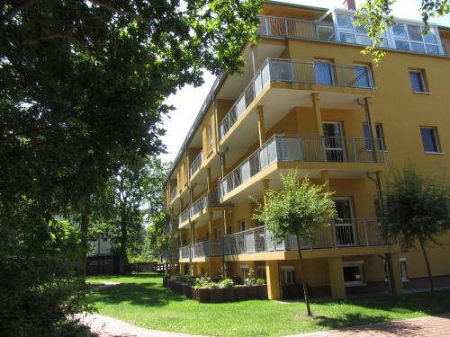 ein Apartmenthaus mit Balkonen und Bäumen in der Unterkunft Ferienresidenz zur Ostsee in Zempin