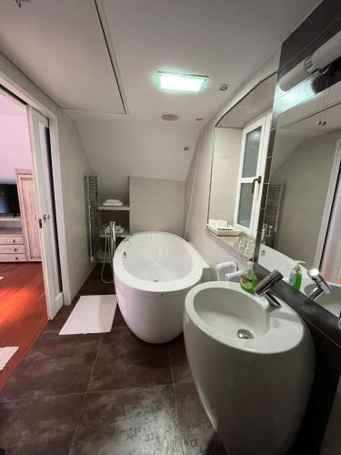 ein Badezimmer mit einer großen weißen Badewanne und einem Waschbecken in der Unterkunft MAMA PALACE in Split