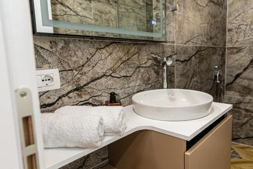 a bathroom with a sink and a marble wall at Villa The Old Bakery in Qeparo