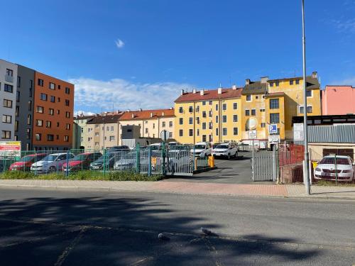 a parking lot with cars parked in a parking lot with buildings at Penzion u Vlčků in Cheb