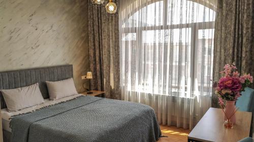 sypialnia z łóżkiem i dużym oknem w obiekcie Harmonia Garden Hotel&Restaurant w Garni