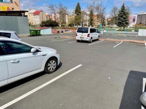 two white cars parked in a parking lot at Penzion u Vlčků in Cheb
