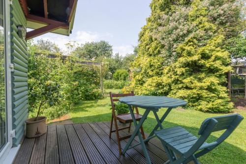 a patio with a table and chairs on a deck at Cobweb Cottage Studios in Spooner Row