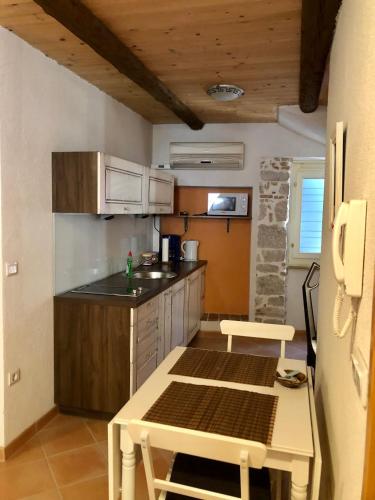 a small kitchen with a table and a counter top at Romantic studio old town in Vrsar