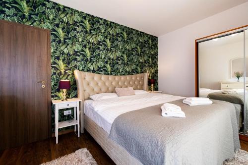 a bedroom with two beds and a green wall at Nature Apartment - Minutes Away from the Old Town and AFI Mall in Braşov